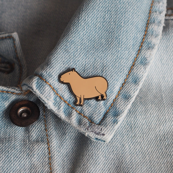 A capybara enamel pin on a denim jacket - Nutmeg and Arlo