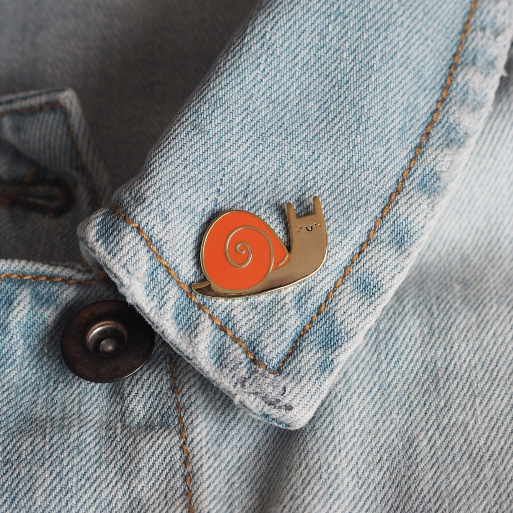 snail enamel pin on a denim jacket - nutmeg and arlo