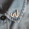 cute wiggly worm enamel pin on a denim jacket - nutmeg and arlo